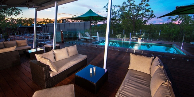 outdoor view of Cicada Lodge brown wicker seats with cream covers near a swimming pool
