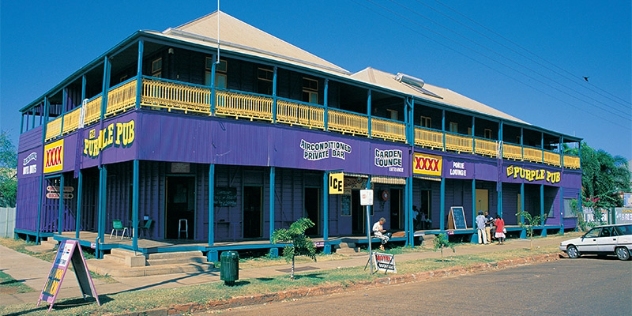 queenslander style pub painted dark purple with contrasting yellow railings